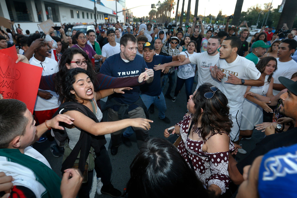 Protestors surround a Trump supporter on S. Almaden Boulevard outside the San Jose Convention Center as Presidential candidate Donald Trump holds a rally in San Jose, Calif., Thursday, June 6, 2016. (Patrick Tehan/Bay Area News Group)